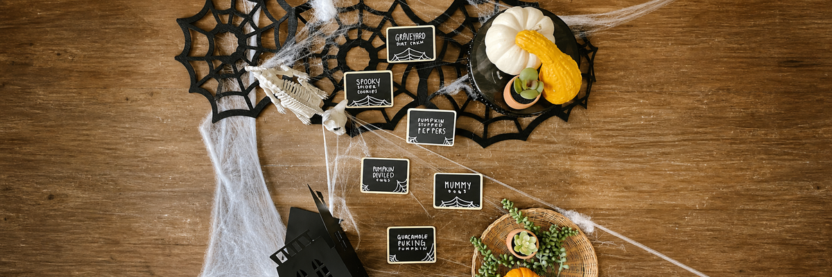 Mini chalkboard signs as Halloween food labels on a rustic wood tabletop — Savvy & Sorted holiday hosting