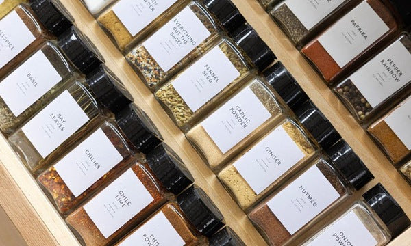 Pantry shelves with organized glass jars and minimalist labels