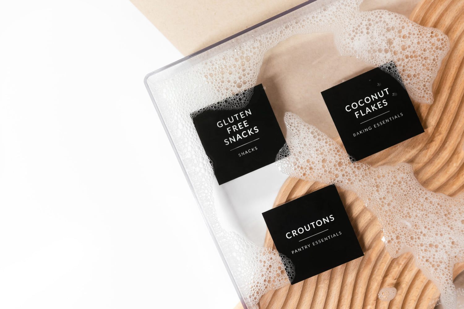 Savvy & Sorted Black Minimalist Pantry Labels submerged in soapy water — waterproof demo showing labels staying crisp and adhered underwater