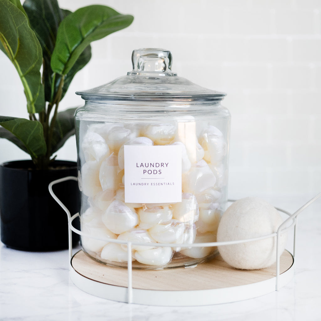 Organized bathroom counter with labeled glass jar and laundry pods - Savvy & Sorted