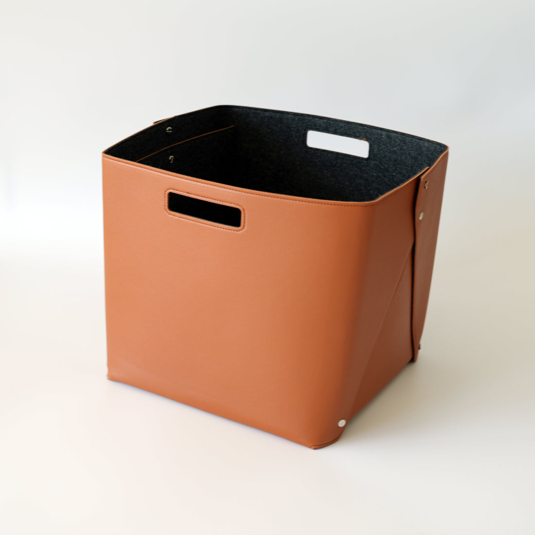 Brown storage bin with black interior on a white background