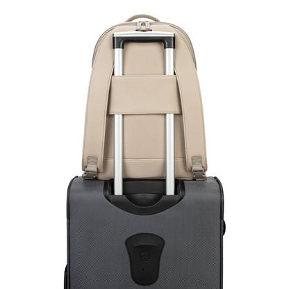 Beige backpack with silver straps attached to a black suitcase on a white background