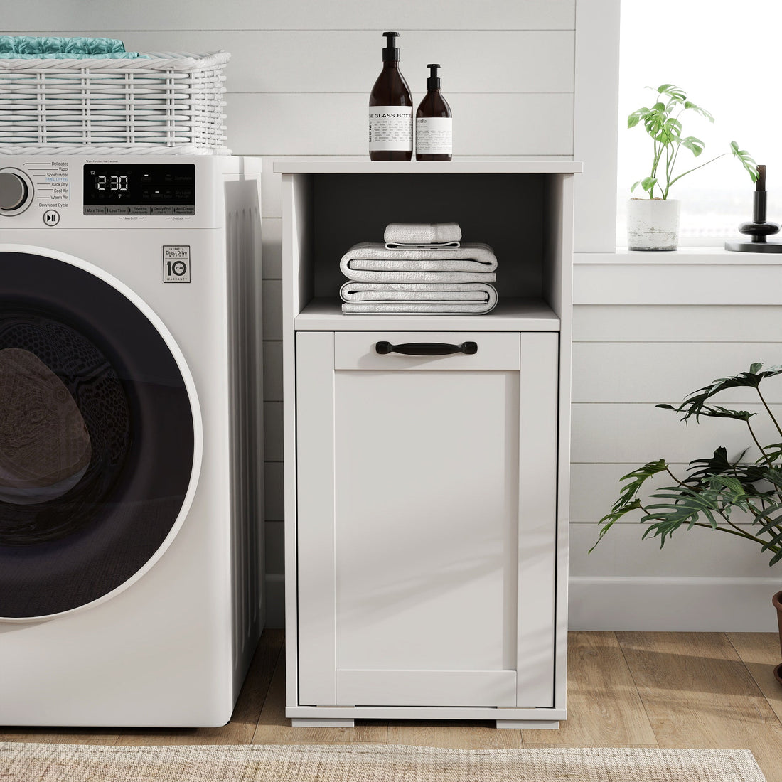 Laundry room with washing machine, cabinet, and cleaning supplies.