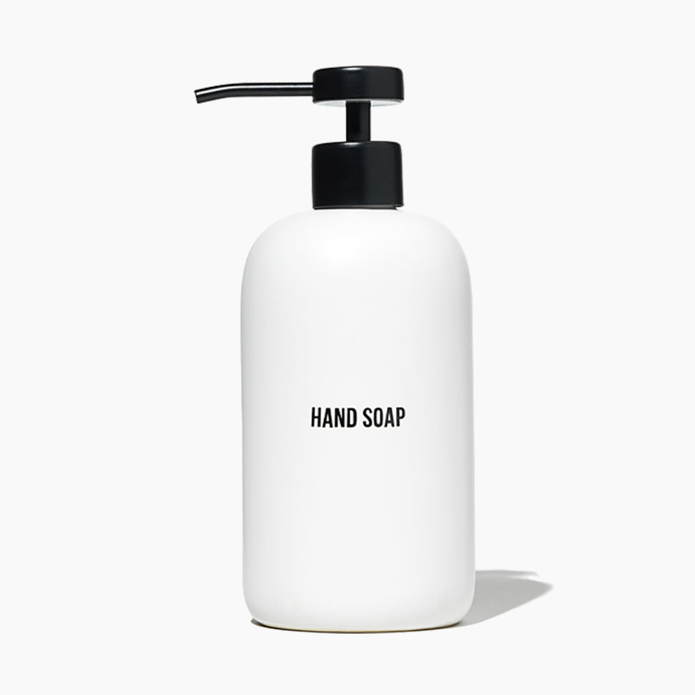 A minimalist white hand soap dispenser bottle with a black pump and the words &
